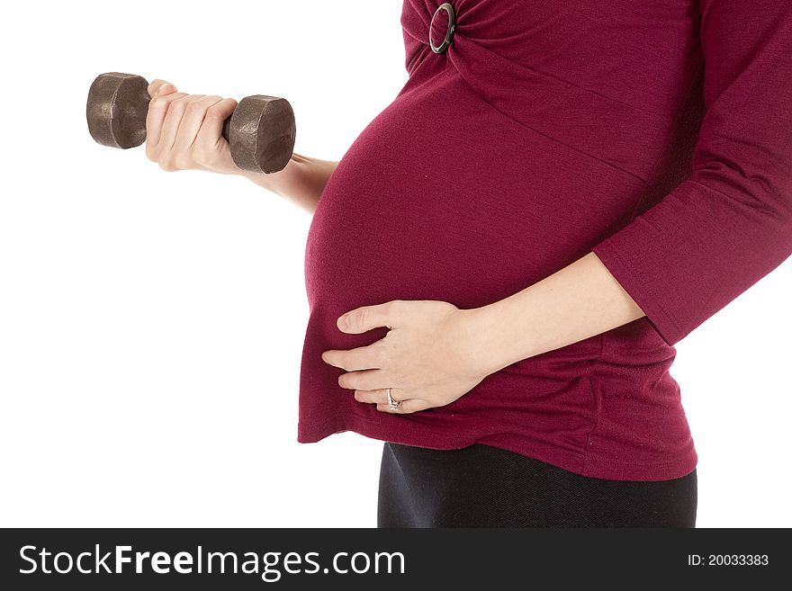 A close up of a pregnant woman working out with weights. A close up of a pregnant woman working out with weights.