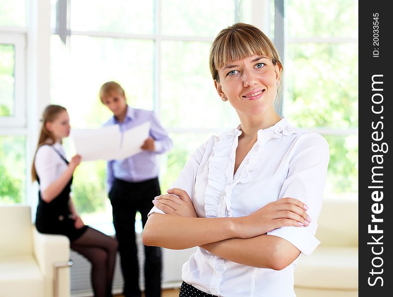 Business woman in office and collegues on background. Business woman in office and collegues on background