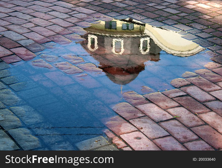 Reflection building in the puddle after rain on summer. Reflection building in the puddle after rain on summer