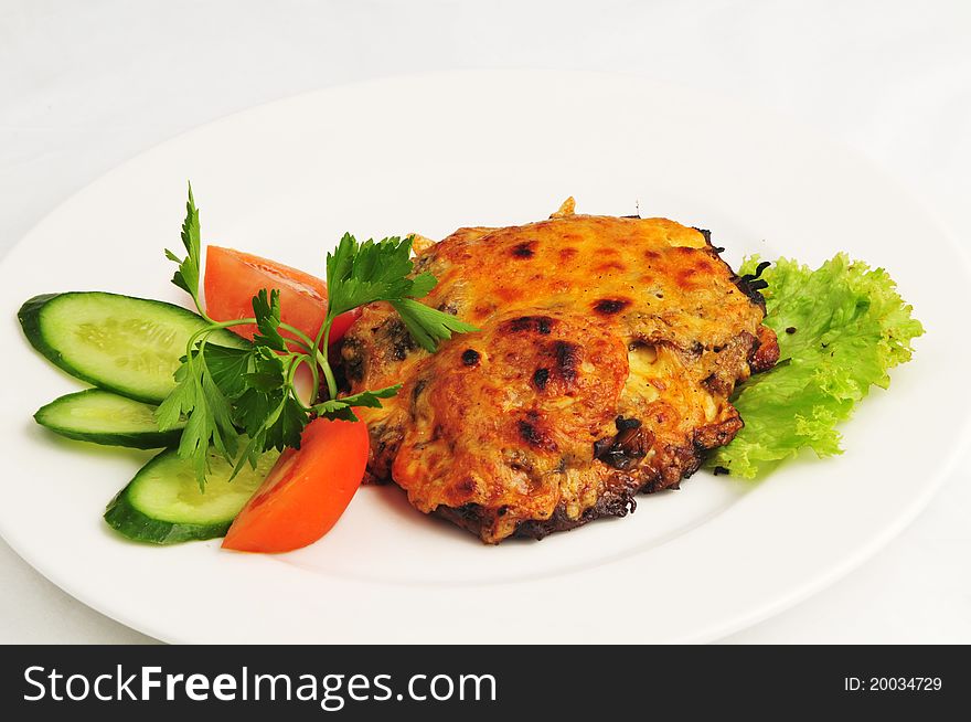 The baked meat with vegetables on a white background