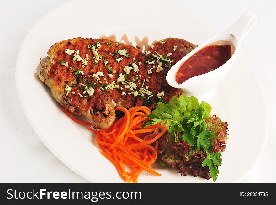 Meat on a grill with a garnish on a white plate