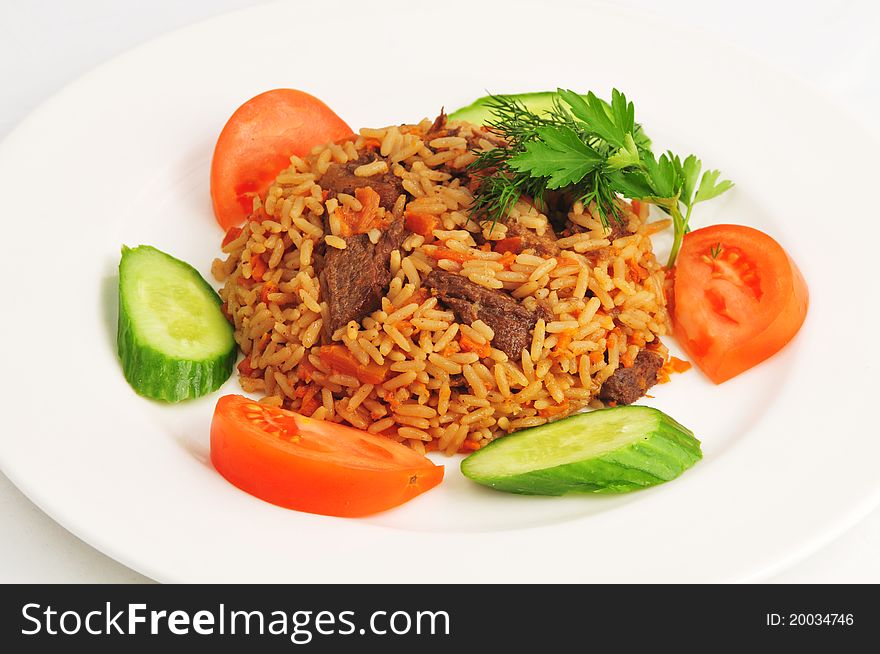 Pilaf with vegetables on a white plate