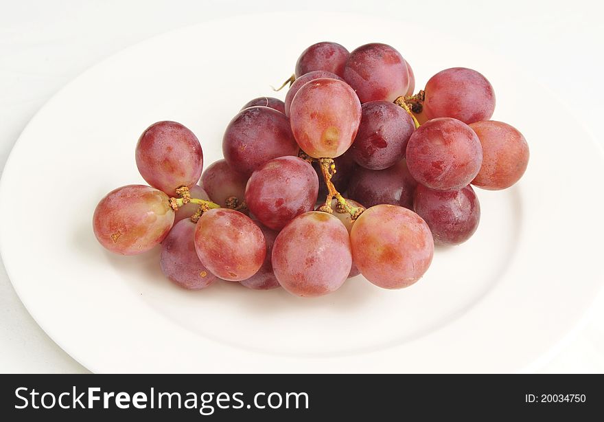 Grapes on a plate on a white background