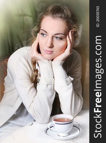 Young blond girl with tea in the cafe. Young blond girl with tea in the cafe