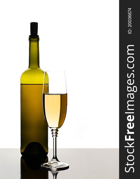 Bottle and glass of white wine on white