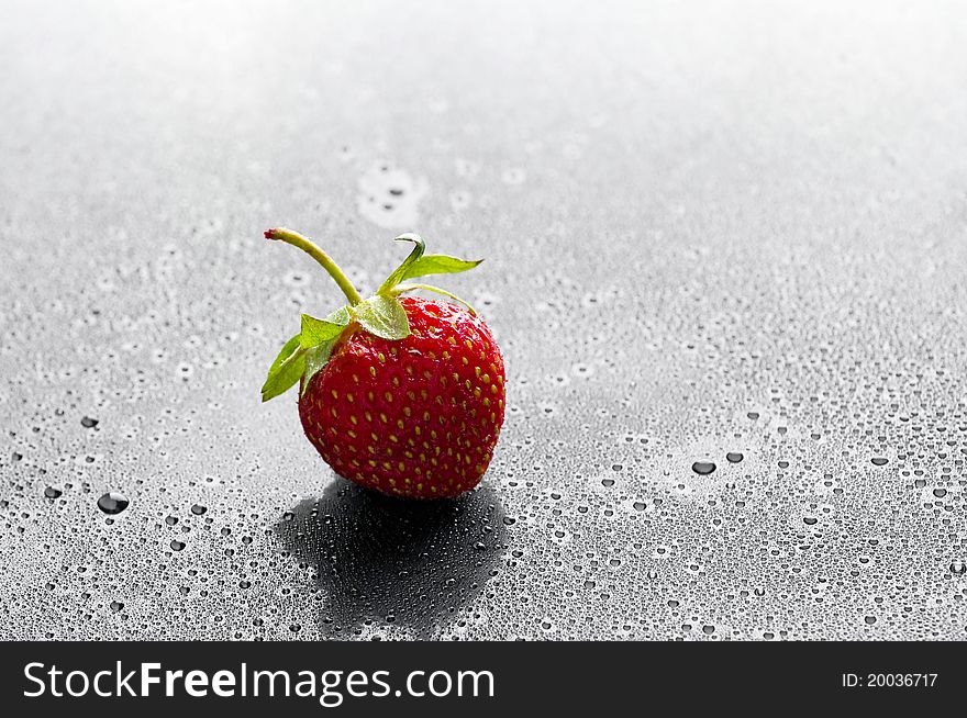 Red strawberry with water drops over black