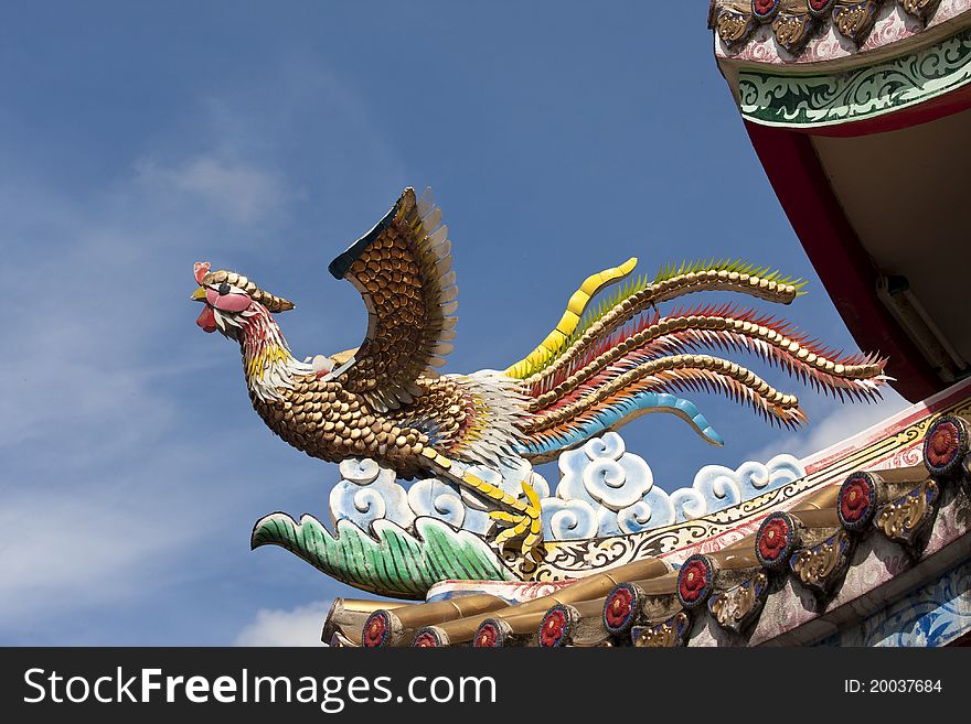 Chinese phoenix sculpture on roof of temple . Chinese phoenix sculpture on roof of temple .