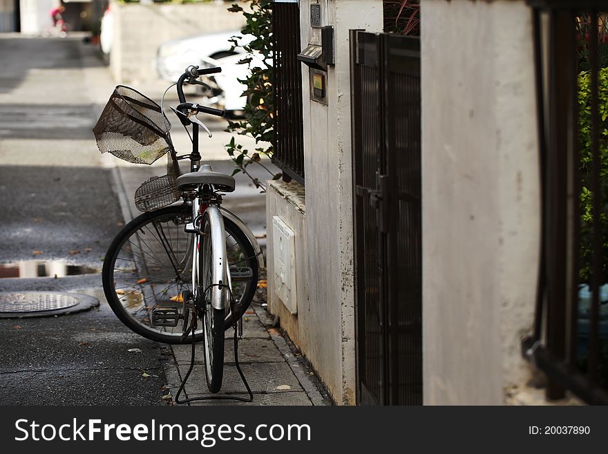 Lone bicycle on a street with a broken basket.