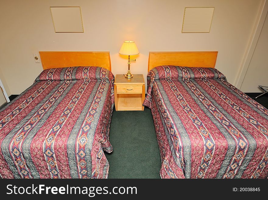 Typical and simple hotel bedroom with double beds. Typical and simple hotel bedroom with double beds.