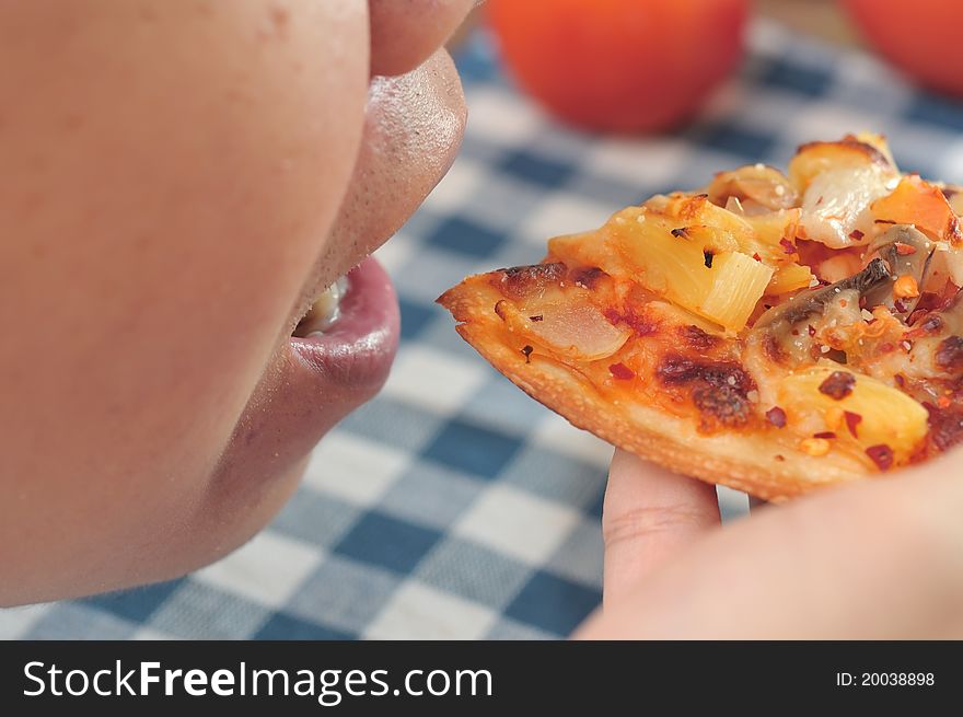 Hand taking freshly baked pizza close to mouth. Hand taking freshly baked pizza close to mouth.
