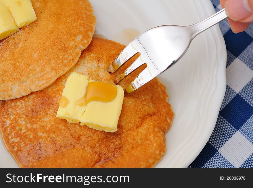 Hand using fork and eating freshly made pancakes. Hand using fork and eating freshly made pancakes.
