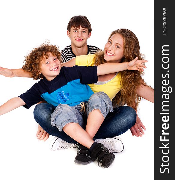 Mother and children sitting on floor isolated over the white background. Mother and children sitting on floor isolated over the white background.