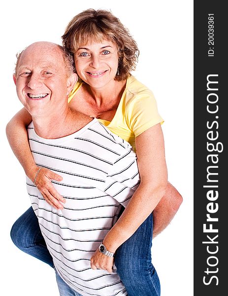 Senior man giving woman piggyback ride, indoors..