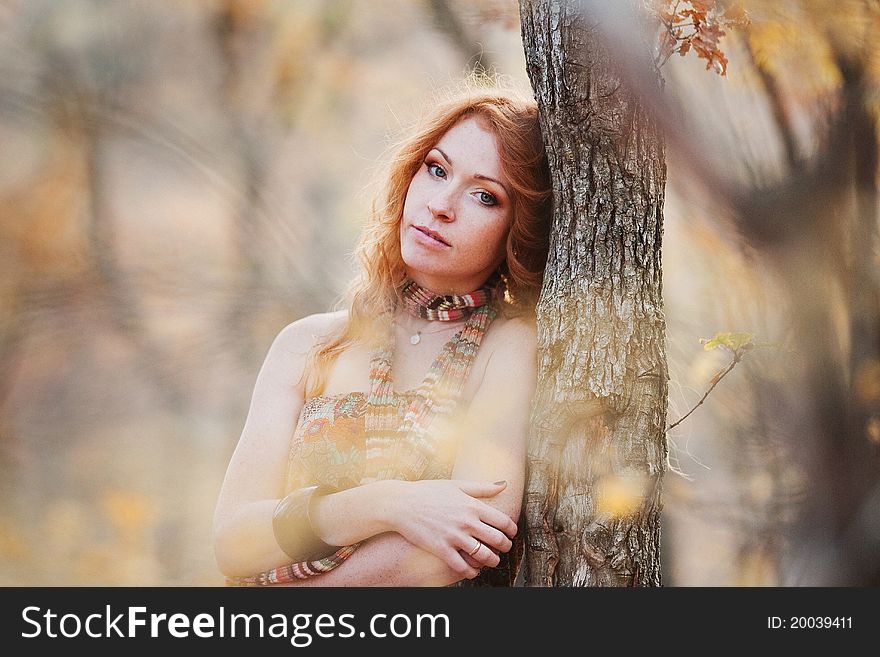 The red-haired girl in autumn leaves outdoor shot