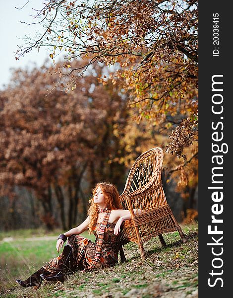 The red-haired girl in autumn leaves outdoor shot