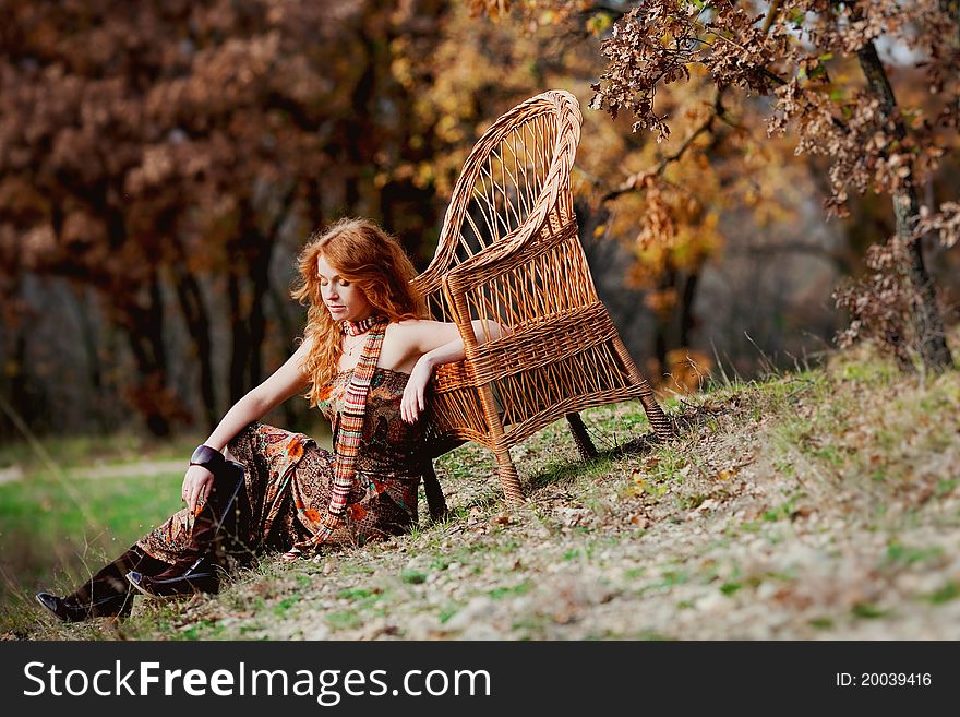 The red-haired girl in autumn leaves outdoor shot