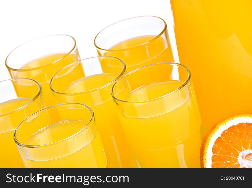 Pitcher and glasses full of juice, isolated on white; closeup