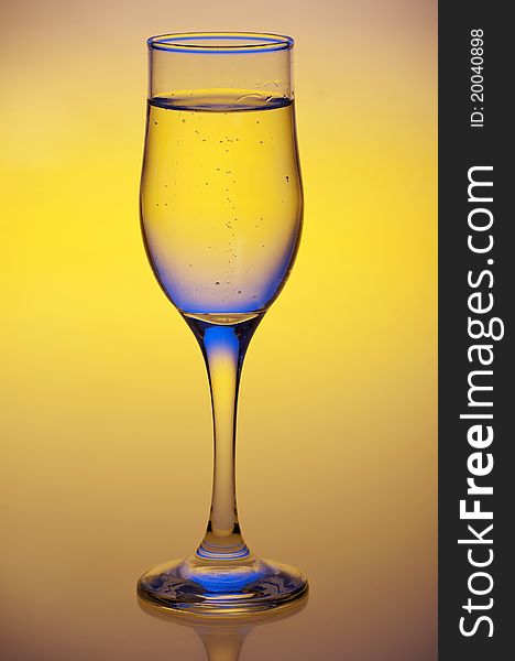 Glass with mineral water isolated on a yellow background