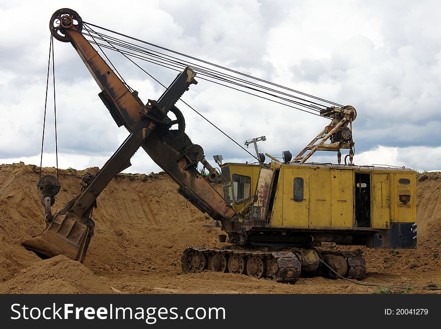 An excavator working on sand. An excavator working on sand