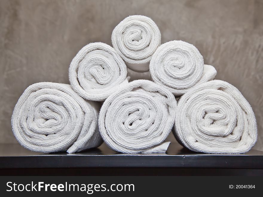 Bunch of white towels in bathroom shelf