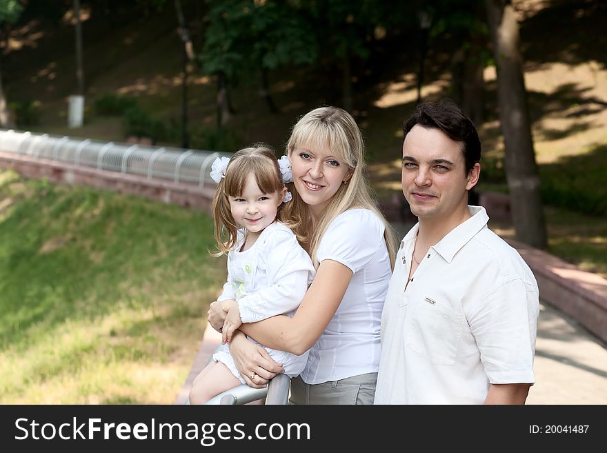 Family at park. Nice girl, mother and father