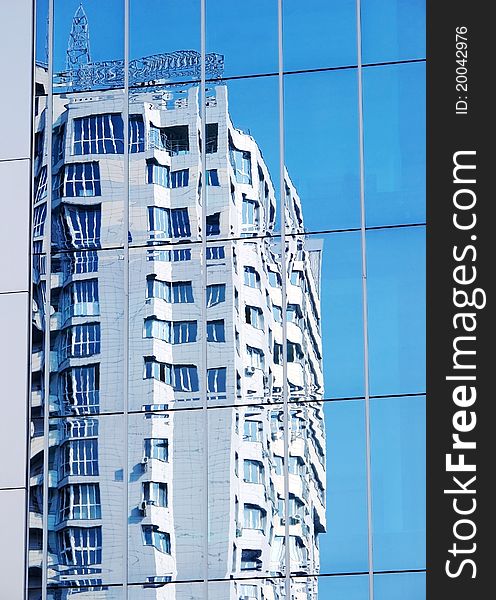 Apartment house in a city. Reflexion in a mirror wall. The blue sky. Apartment house in a city. Reflexion in a mirror wall. The blue sky.