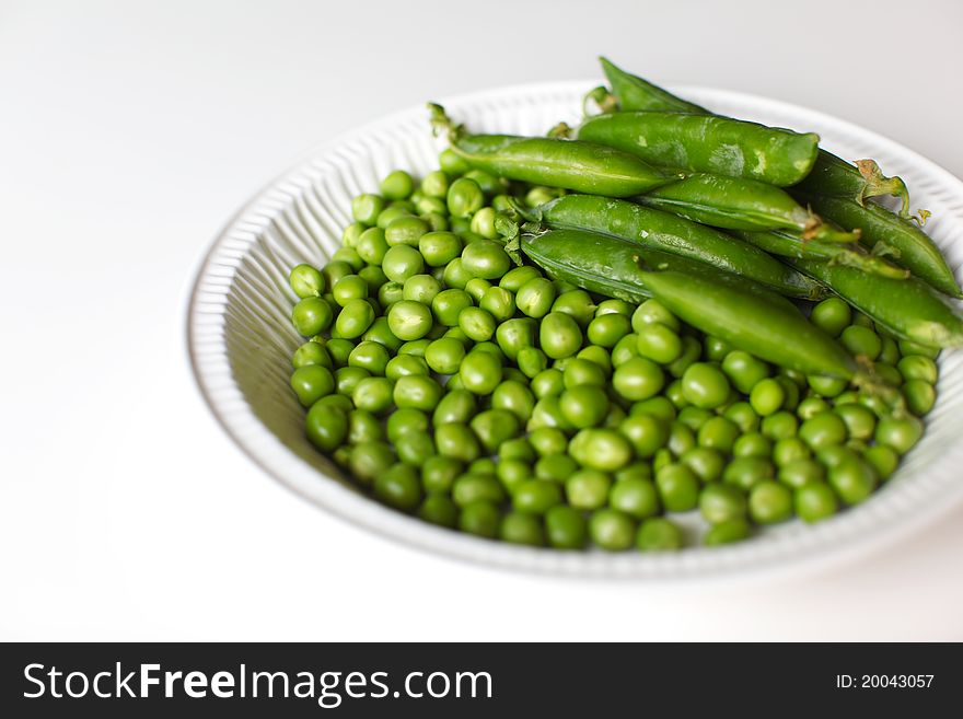 Fresh green peas shelled and in pods.