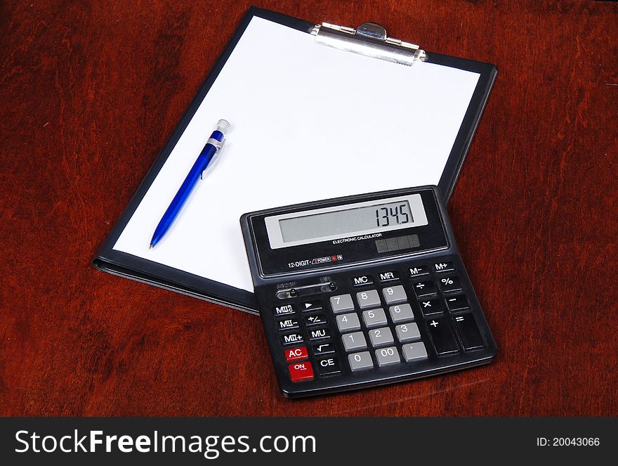 Calculator with notebook on table