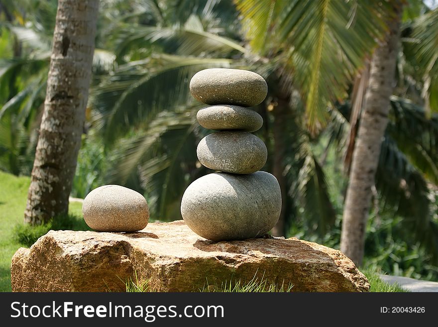 Pile of pebble Stones against the background of palm trees