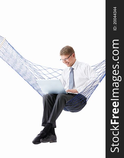 A young man with laptop in hammock isolated