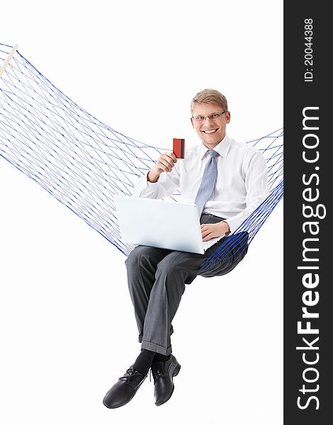 Businessman with laptop and credit card is isolated in a hammock