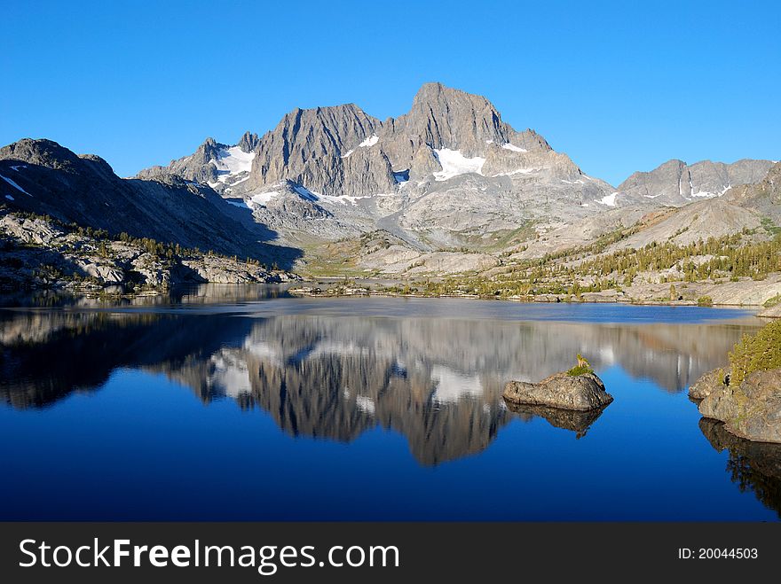 A majestic peak reflected in the calm morning water of Garnet Lake in the High Sierra. A majestic peak reflected in the calm morning water of Garnet Lake in the High Sierra