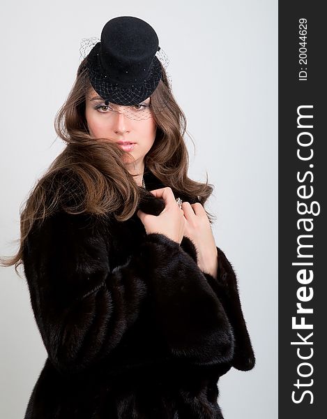 Close-up of beautiful young smiling woman in a fur coat and hat. Close-up of beautiful young smiling woman in a fur coat and hat