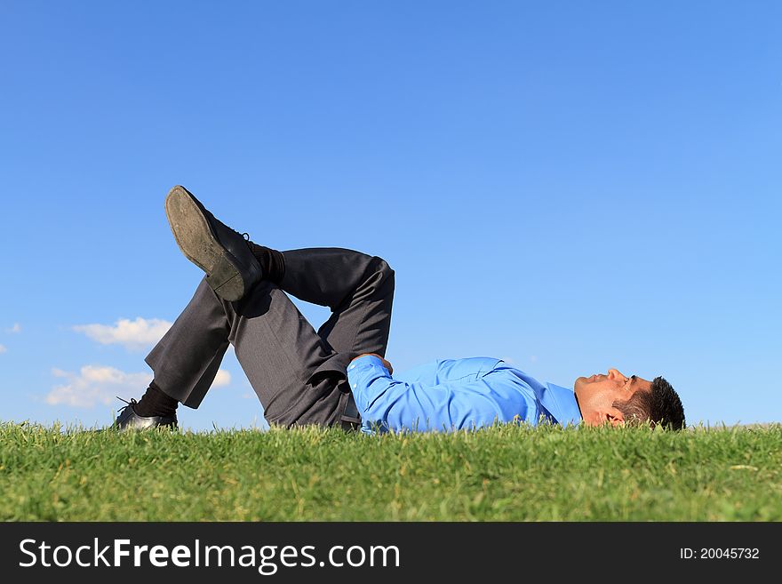 Young businessman relaxing on green grass. Young businessman relaxing on green grass