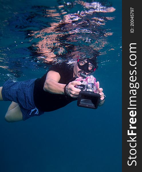 Swimming photographer with camera, Maldives. Swimming photographer with camera, Maldives
