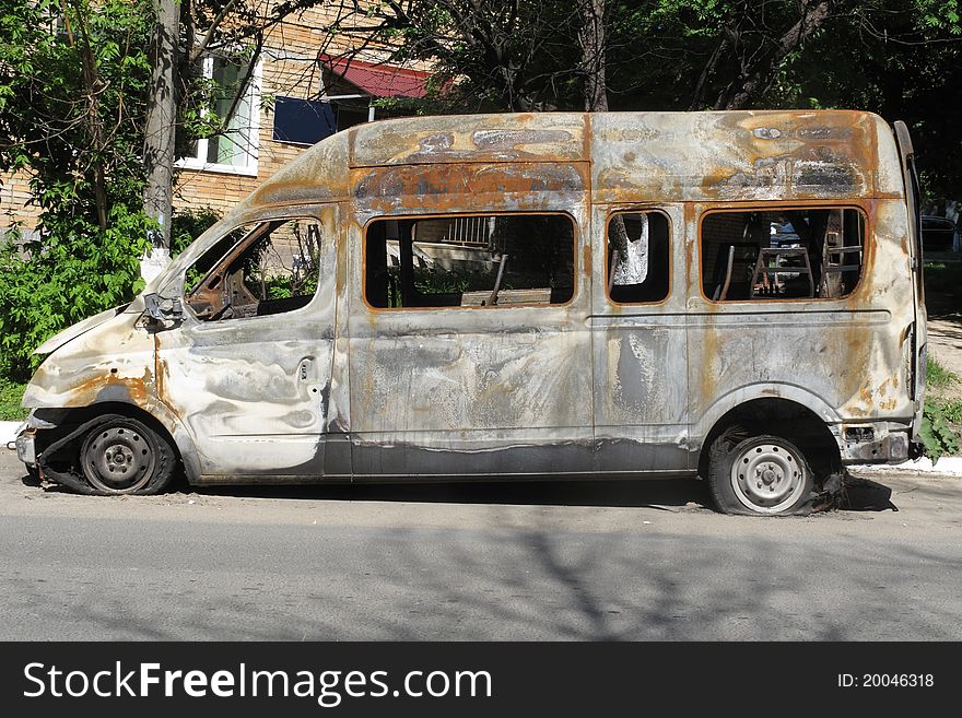 The image of burnt bus stands on the street