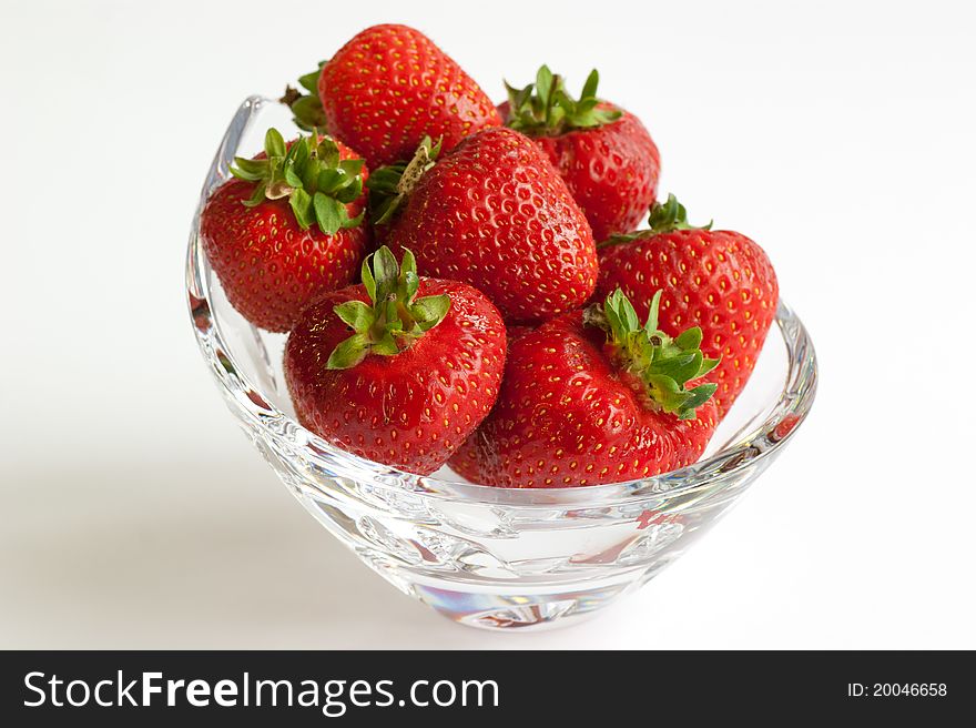 A crystal glass bowl of ripe red strawberries. A crystal glass bowl of ripe red strawberries