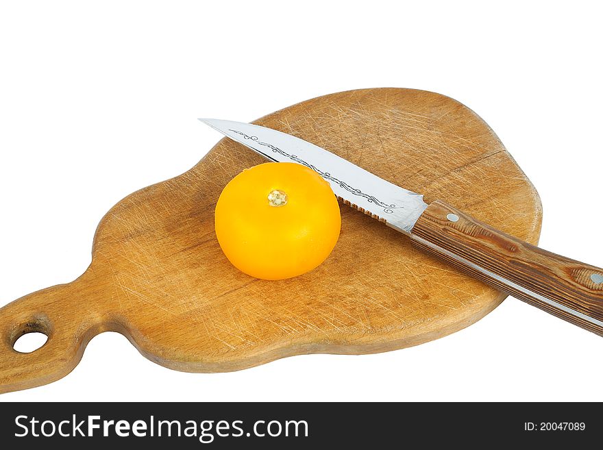 Tomato with a knife on a cutting board