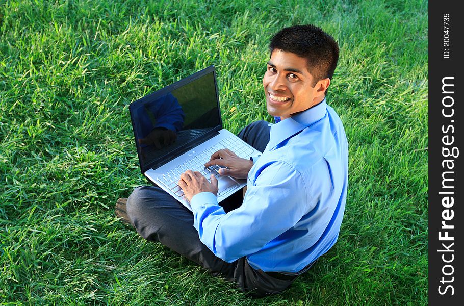 Young businessman working with laptop at the park. Young businessman working with laptop at the park