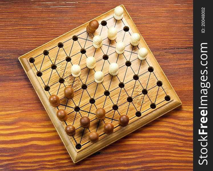 Chinese checkers board with pegs on table