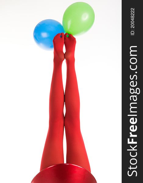 Female feet in red stockings with balloons isolated in white