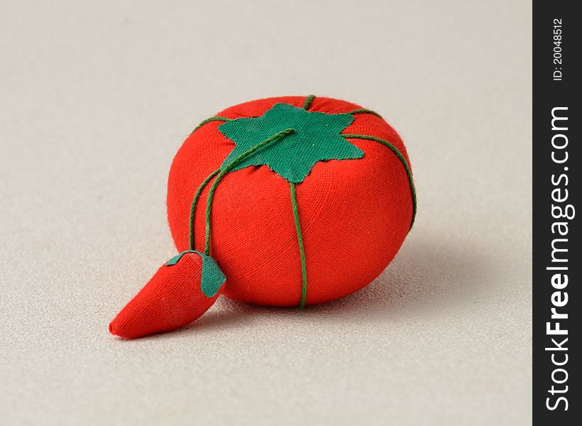 Pincushion shaped as a redvine tomato with strawberry attached. Pincushion shaped as a redvine tomato with strawberry attached.