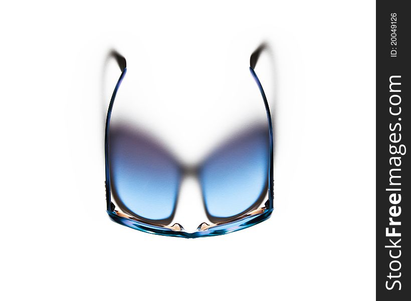 A clean and simple birdâ€™s eye view shot of the top of a pair of blue and purple sunglasses, casting a shadow in the shape of lens shades as a gradient of light blue to dark purple, on a plain white background