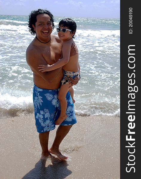 A Hispanic father and son by the ocean