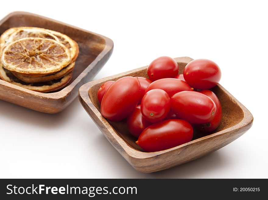 Cocktail tomatoes and lemons in the wood bowl