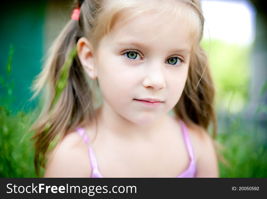 Cute little girl smiling in a park close-up