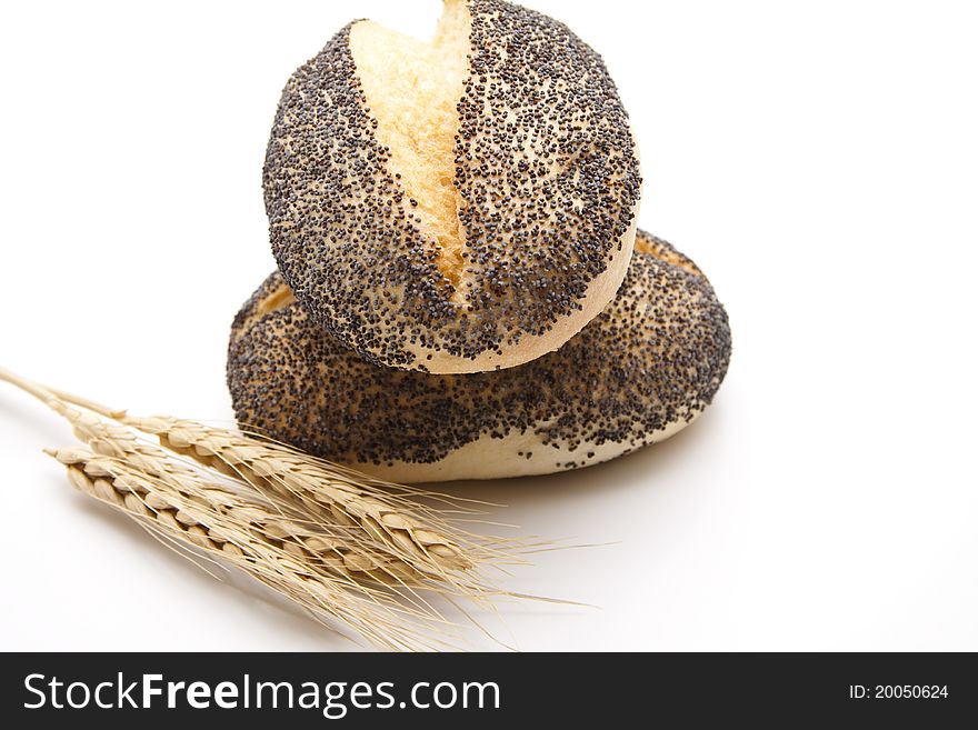 Poppy roll with wheats onto white background