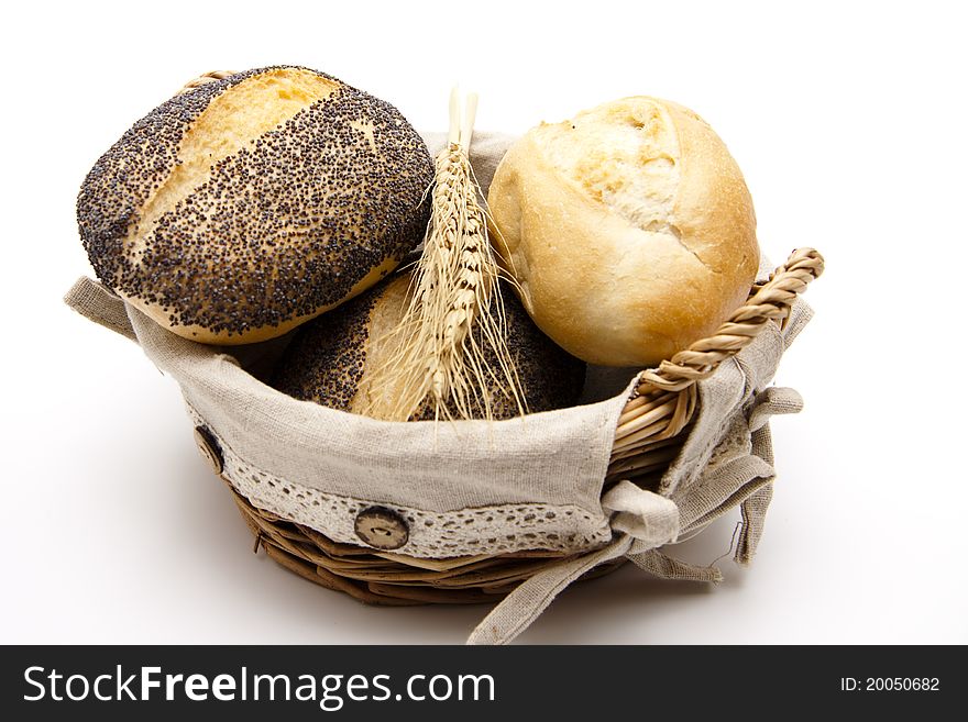 Roll with wheats in the basket onto white background. Roll with wheats in the basket onto white background