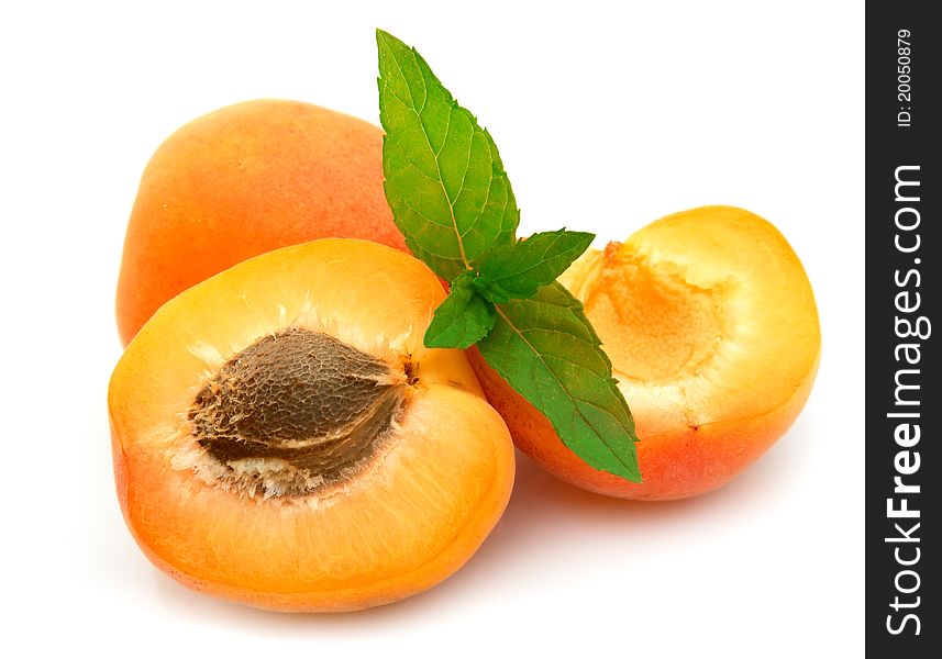 Ripe apricots with stone and mint on white background. Ripe apricots with stone and mint on white background