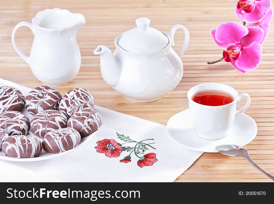 Cup of tea, teapot and chocolate iced spice cakes